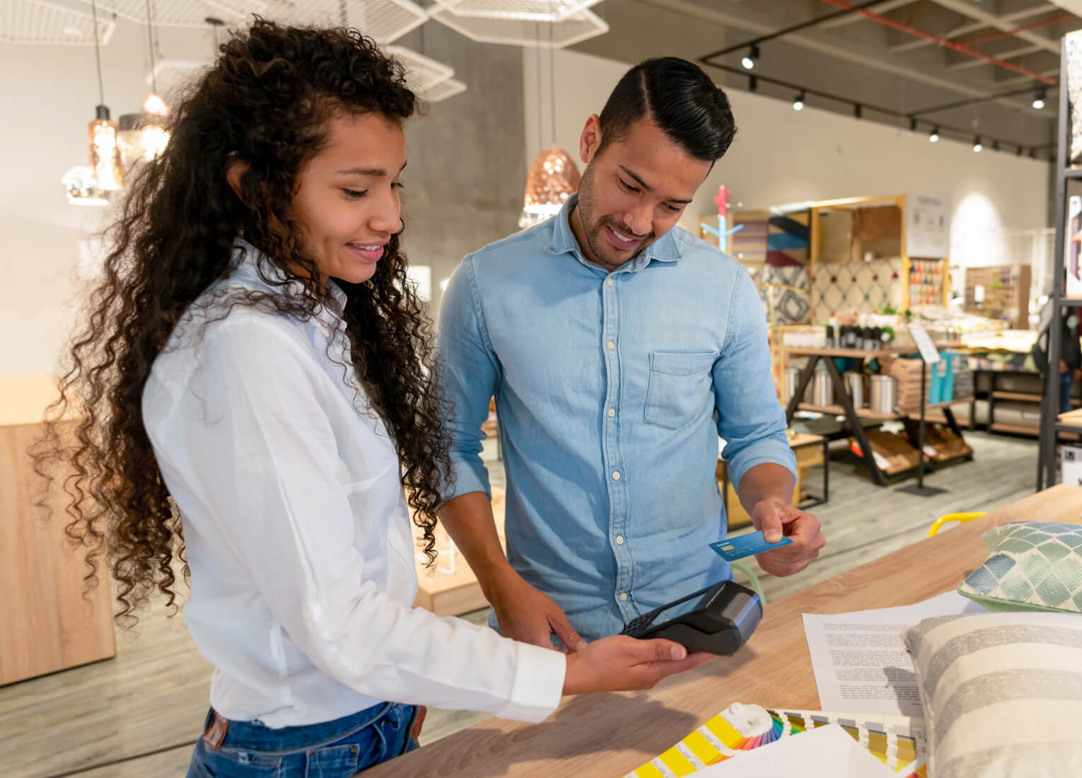 Customer in furnishings store using debit machine to pay with debit card