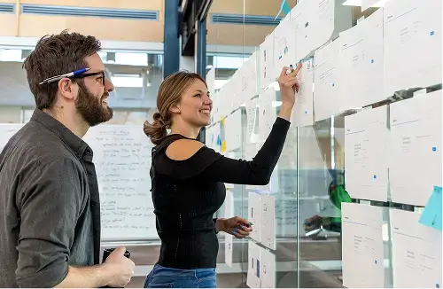 Woman writing on board while talking about her Paystone career